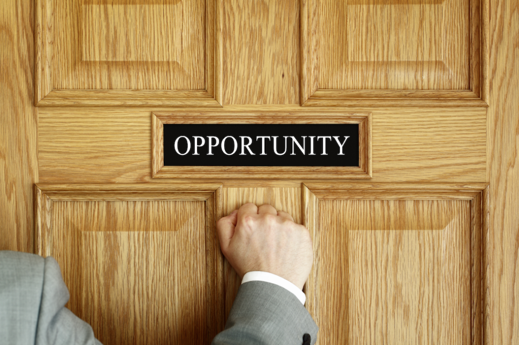 Hand knocking on a door labelled "opportunity"